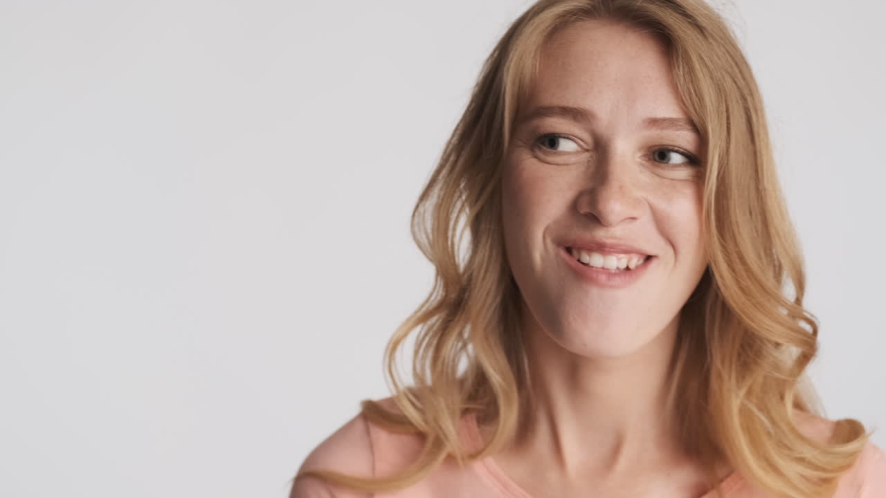 Caucasian woman blowing bubblegum on camera.