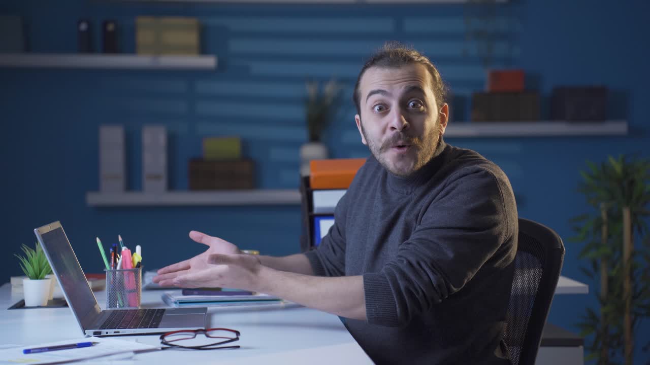 Confused home office worker looks at camera.