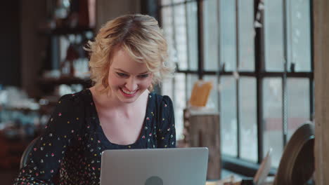 diseñadora de moda usando una computadora portátil en un estudio filmado en r3d