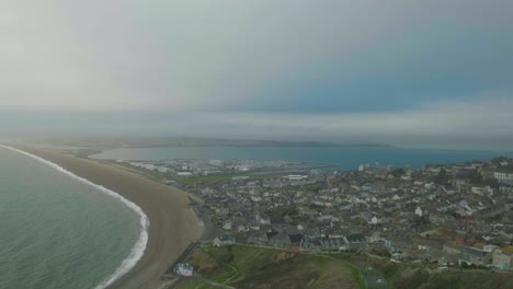 4k cinematic landscape shot of chesil beach on top of portland, dorset on a cloudy day