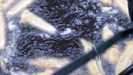 close shot of mans hand cooking beguni with egg plant street food. bangladeshi street food. indian street food