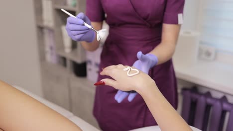 applying cream to a woman's hand at a beauty spa