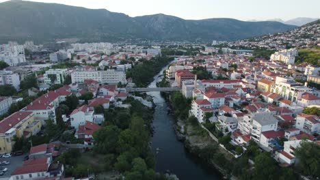 mostar evening glow by historic neretva river, aerial fly-over