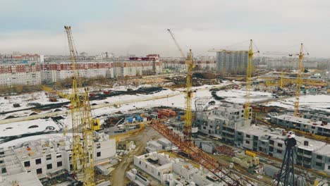 big construction cranes located in line on ongoing building