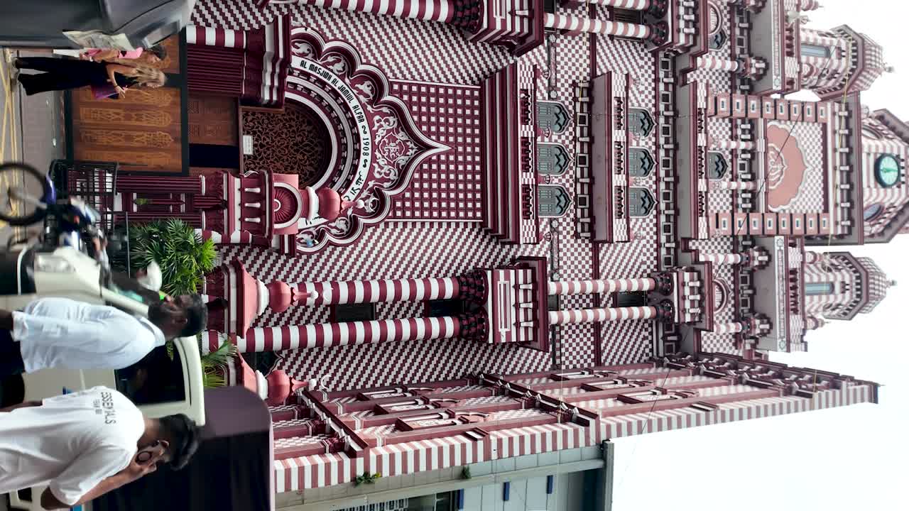 Jami Ul-Alfar Mosque in Colombo, Sri Lanka, showcases vibrant red and white architecture, surrounded by bustling street life. vertical video, slow motion