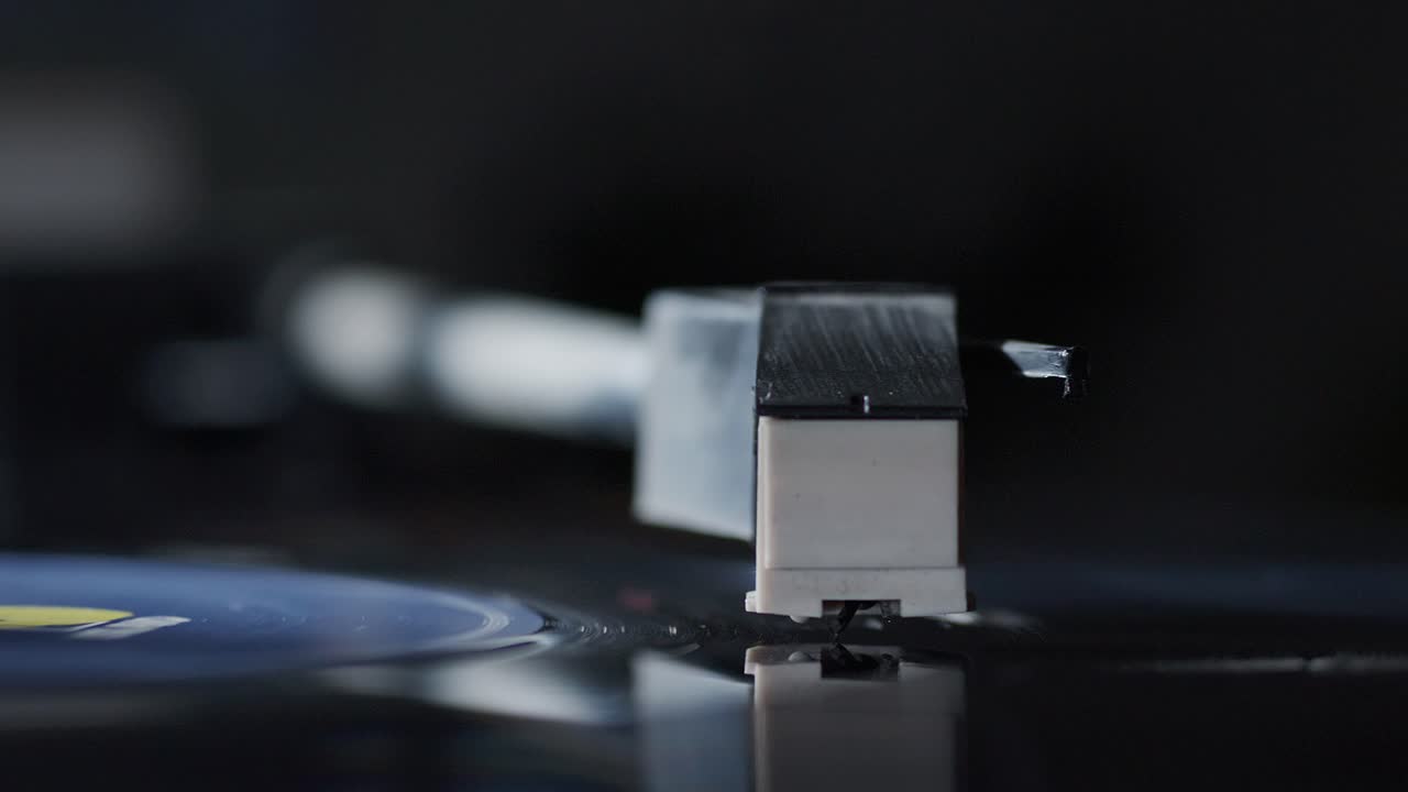 Splendido primo piano ravvicinato della puntina di un giradischi mentre riproduce un disco e poi si ferma