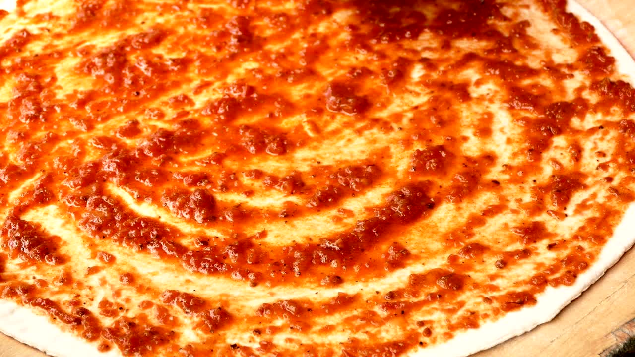 Filmato 4K, primo piano di uno Chef che stende l'impasto per la pizza.