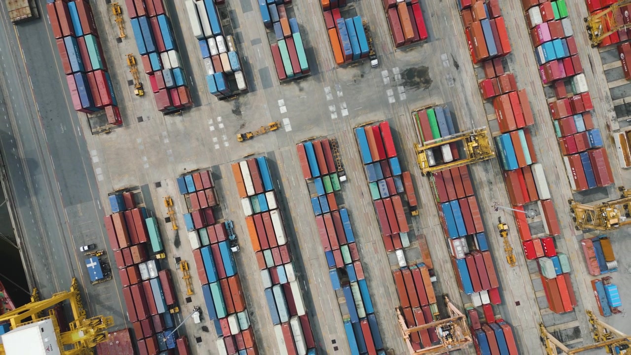 Huge Container Shipping Port Area Facility with Stacked Containers, Trucks, Cranes and Cargo Shipping Vessels
