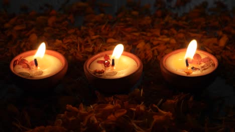 petals falling behind diyas or lamps lit up for diwali 'festival of light', the most important ancient hindu festival celebrated signifying victory of light over darkness