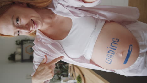 pregnant woman taking a selfie with 'loading' on her belly