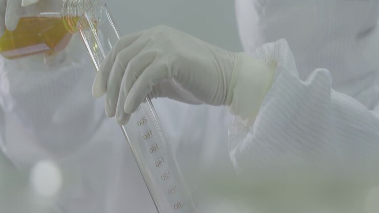 Professional doctor, chemist or scientist equipped with protective suits, face masks, safety goggles, loads liquid sample into flask for biochemical testing laboratories, innovation in medicine