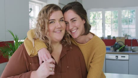 portrait of caucasian lesbian couple embracing and smiling