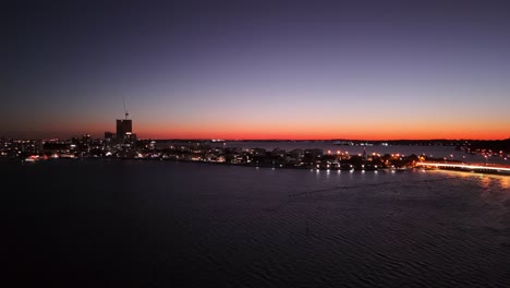 Drone-Volando-Sobre-El-Río-Swan-En-Perth-Al-Atardecer-Mientras-El-Cielo-Se-Ilumina-De-Color-Naranja