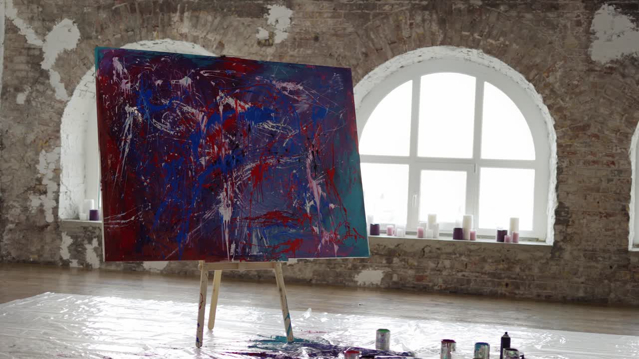 밝은 크리에이티브 스튜디오에서 현대적인 감성적인 그림 큰 캔버스는 easel에 서 있습니다