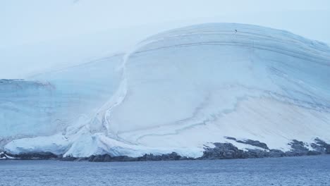 Gletschereisbildung-Am-Meer-In-Der-Antarktis-Mit-Eiskappe-Und-Glattem,-Eisigem,-Schneebedecktem-Eis-Auf-Der-Antarktischen-Halbinsel-An-Der-Küste,-Minimale-Blaue-Küstengeographie-Und-Landschaftskulisse