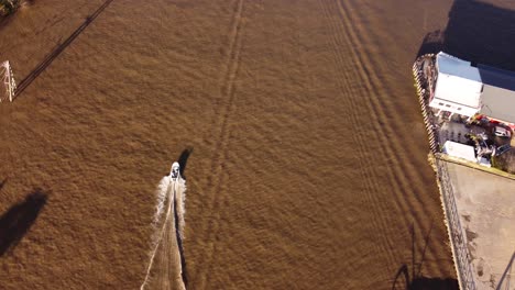 Motorboat-leaves-water-wake-on-brown-waters-of-Parana-river-in-Buenos-Aires-province,-Argentina