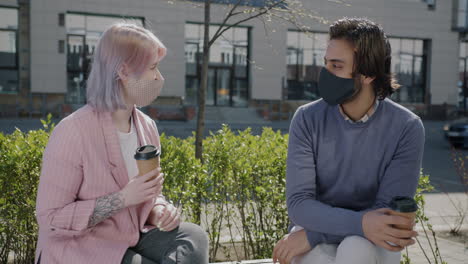 couple with masks talking outdoors