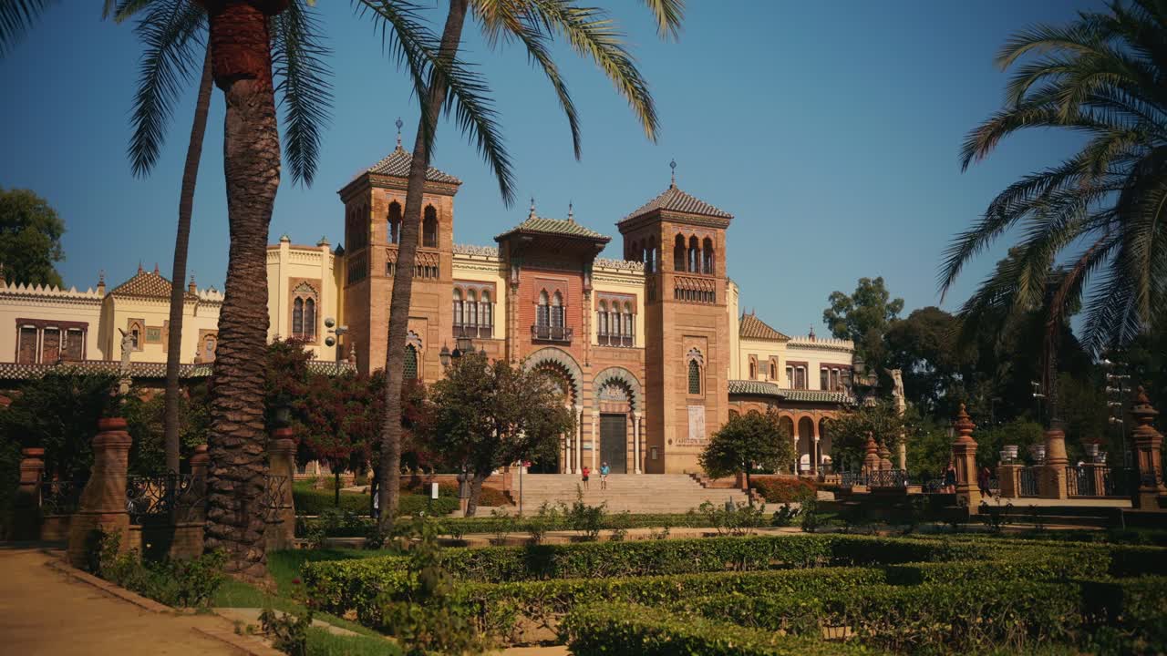 Palazzo storico grandioso circondato da palme e giardini.