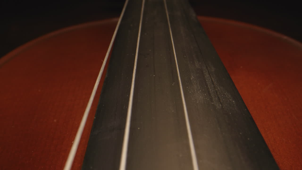 Slider shot from the bridge of a violin up the neck, resembling a roadway.