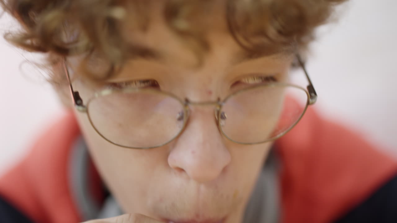 Primer plano de joven con gafas bebiendo con pajita