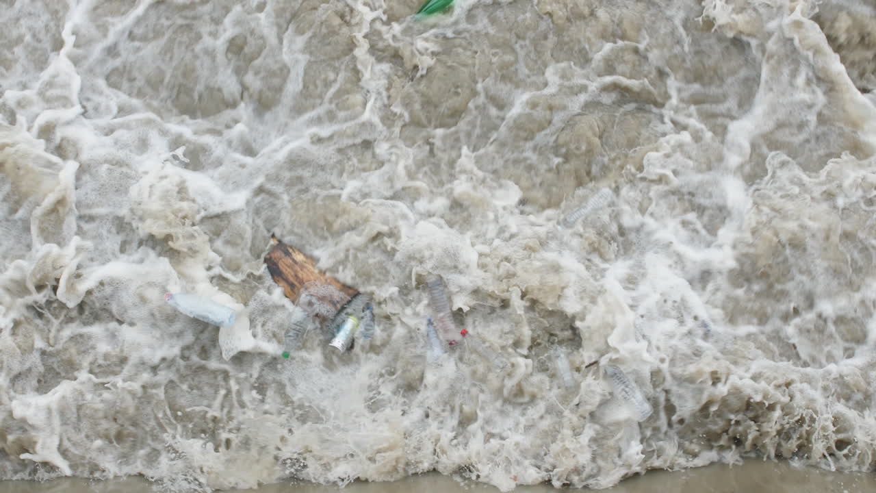 홍수 된 강 의 플라스틱 병 은 몬텔리 에 있는 다리 에서 볼 수 있다