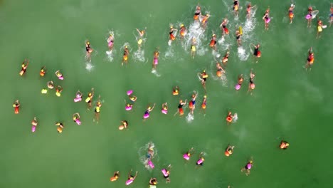 swimmers start of race swimming at sea green drone shot forward