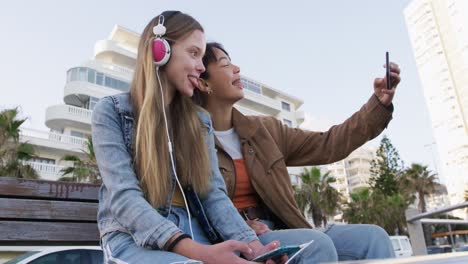 ángulo bajo de un caucásico y una chica de raza mixta usando sus teléfonos