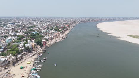 scenic aerial footage of varanasi at sunrise, capturing the peaceful glow of the ganges as it winds past the city's historic ghats.