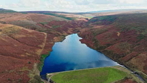 aerial drone video of the beautiful english countryside, wild landscape showing moorlands covered in heather, large lakes and blue water