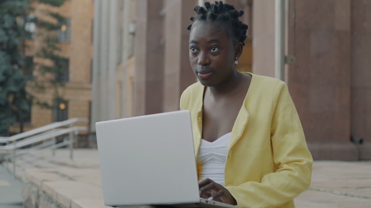 Young Woman Working on Laptop Outdoors