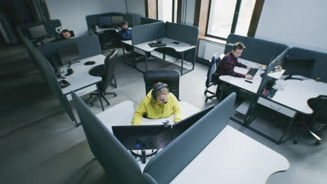 view of people working in a modern office with cubicles