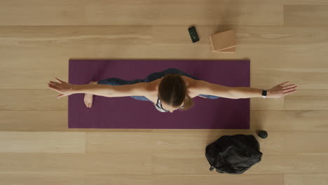 overhead view flexible yoga woman practicing warrior pose enjoying healthy lifestyle exercising in fitness studio training on exercise mat