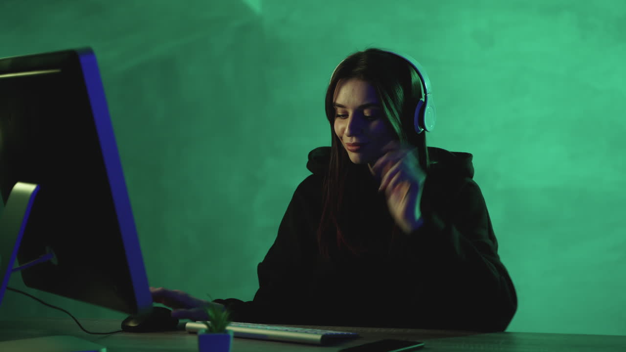 다채로운 배경 에 컴퓨터 와 무선 헤드폰 을 들고 일 하는 여자