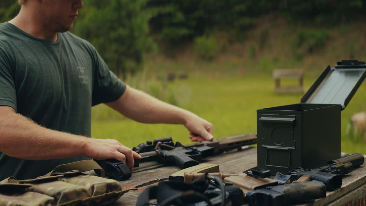 Man preparing rifles and ammunition at a shooting range