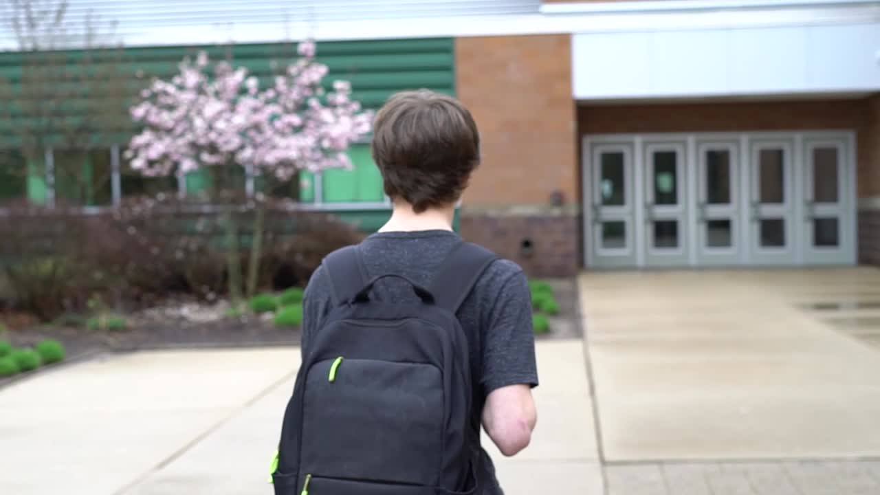 Shot of male student entering high school in Pinckney, Michigan