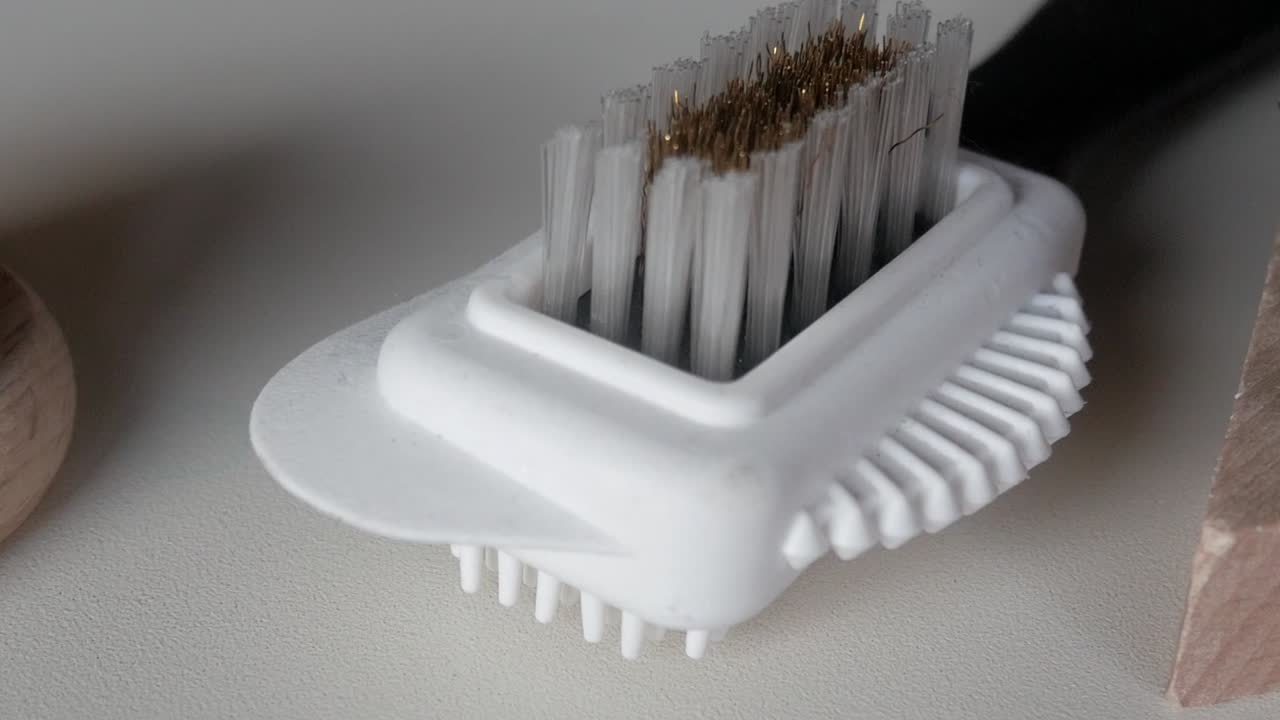 Macro close-up of wooden and plastic shoe polishing brushes showing detailed bristles and smooth textures under soft daylight