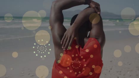 manchas amarillas flotando y fuegos artificiales contra afroamericano hombre en forma realizando ejercicio de estiramiento