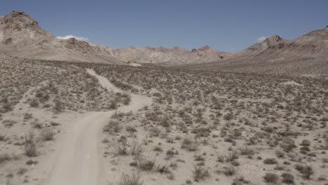 vuelo aéreo a través del valle del desierto, sendero 4x4 en la distancia