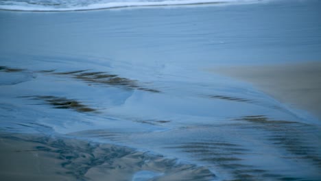 Wasser-Erzeugt-Wellen-Im-Sand-Am-Strand,-Wenn-Die-Gezeitenlinie-Vom-Strand-Zurückweicht