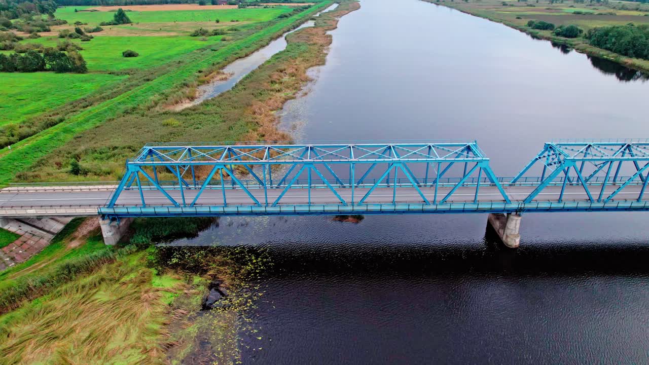 Beautiful aerial view of a blue bridge over a river in Latvia