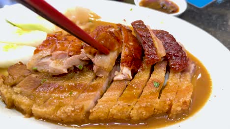 chopsticks serving roast duck on a plate