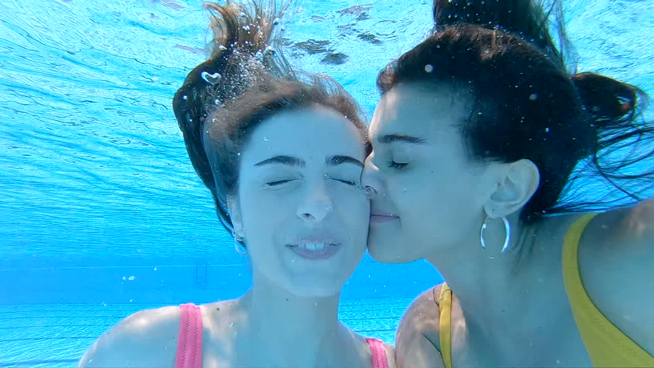 Two Women Kissing Underwater in a Swimming Pool