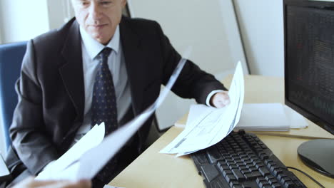 focused grey haired business partners at table with laptops