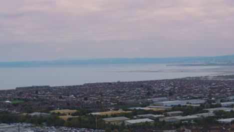view across swansea bay area from port talbot with sprawling suburban landscape with houses and industrial estates with overcast cloudy sky