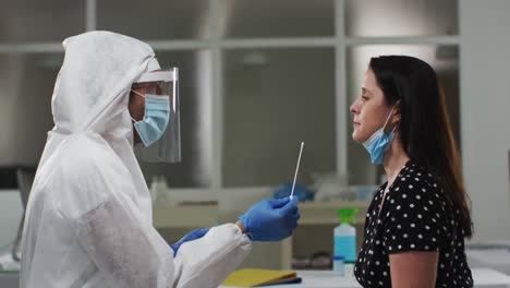 Medical-worker-in-protective-clothing-taking-swab-test-from-female-patient