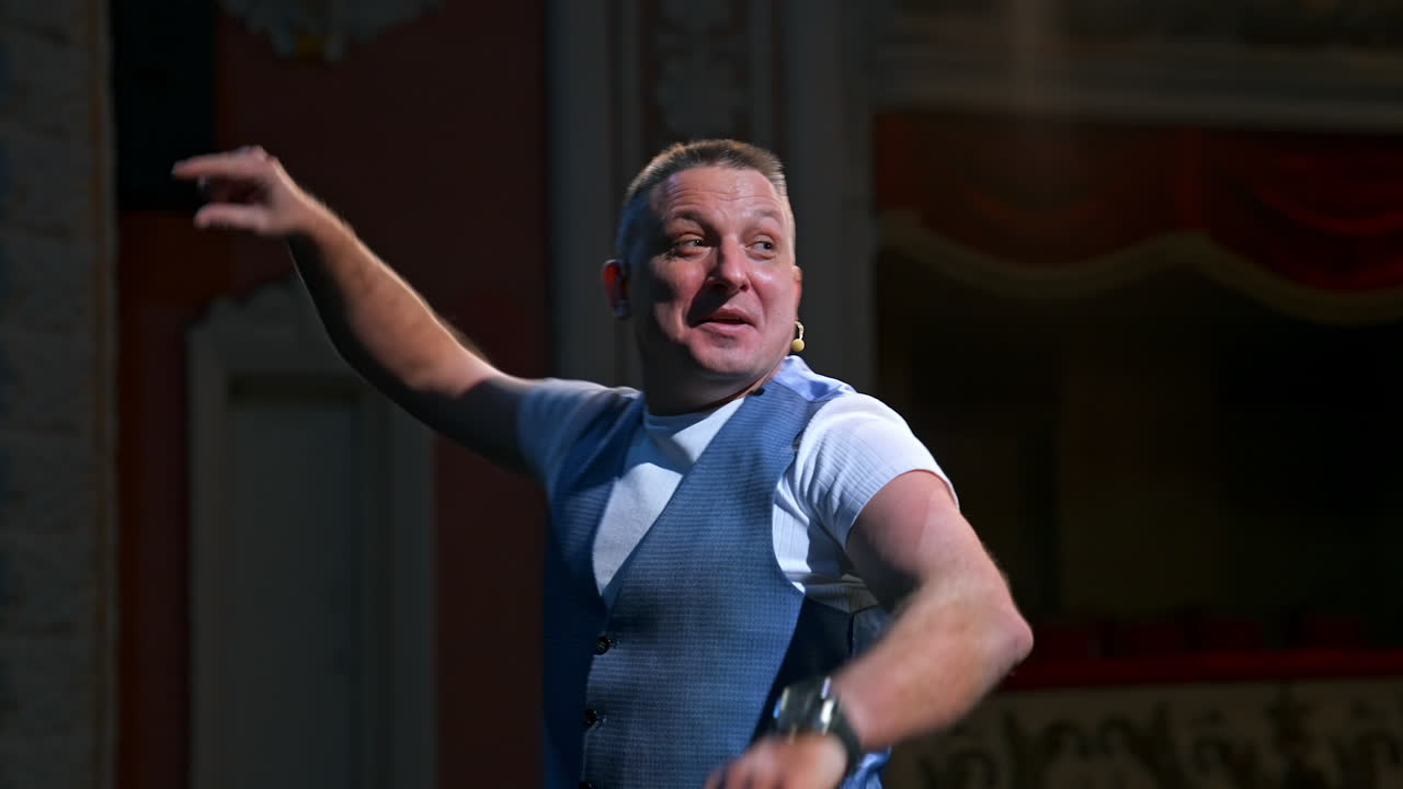 Actor on classic theater stage. Man is speaking in spotlights during the performance. Side view video.