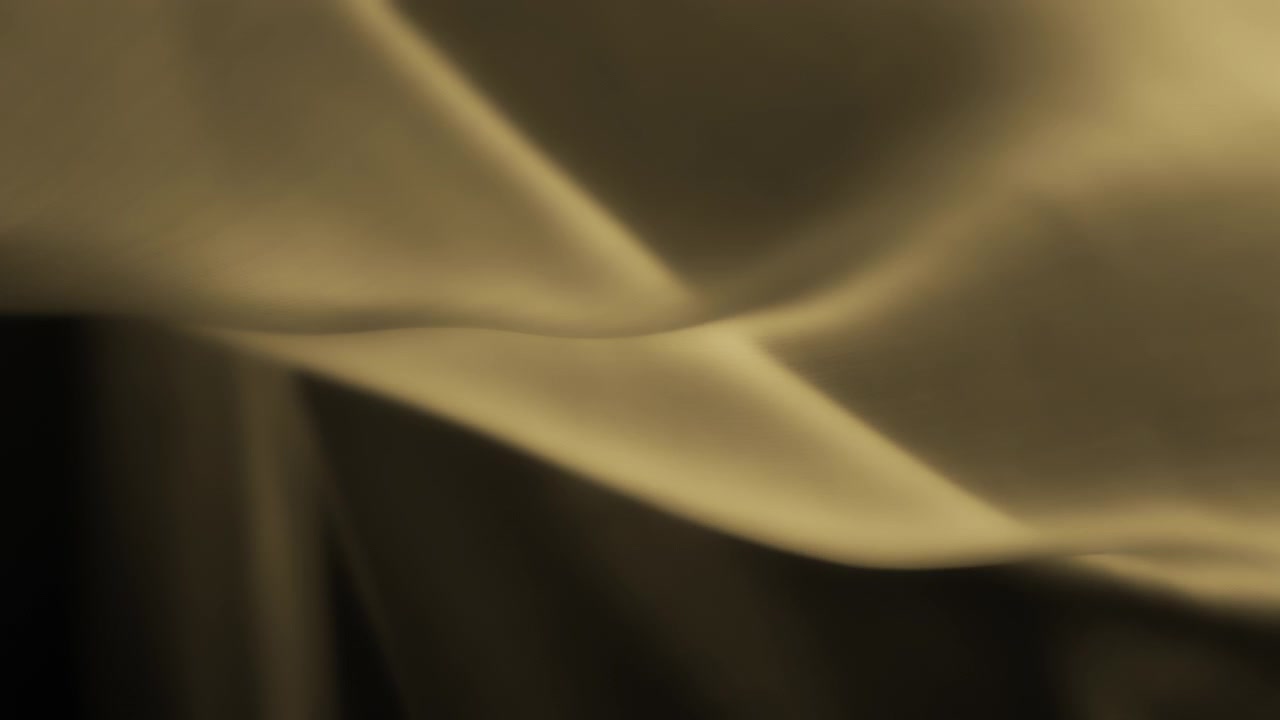 Abstract background of yellow silky textile waving in the wind