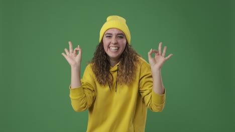 woman giving ok hand sign over green screen