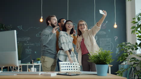 happy team taking a selfie in a modern office