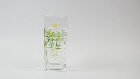 la mano del niño sosteniendo un vaso de agua con diseño floral